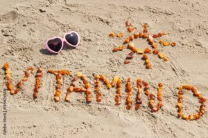 Sunglasses, inscription vitamin D and shape of sun at beach, concept of summer time and healthy lifestyle