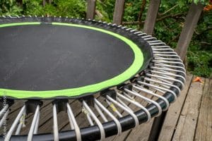 mini trampoline for fitness exercising and rebounding in a backyard patio, spring scenery