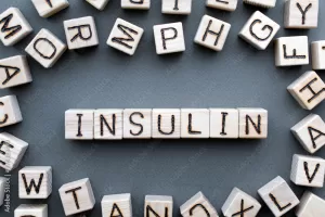 the word insulin wooden cubes with burnt letters, hormone insulin, diabetes treatment  gray background top view, scattered cubes around random letters