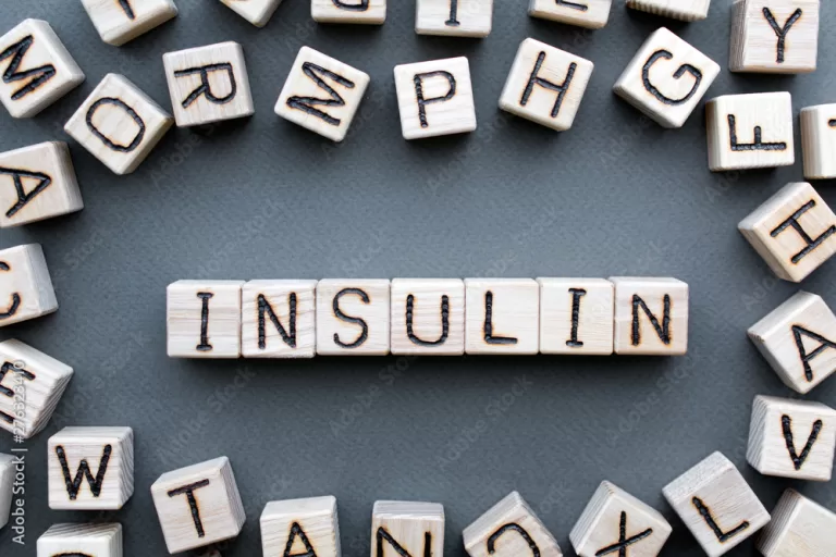 the word insulin wooden cubes with burnt letters, hormone insulin, diabetes treatment  gray background top view, scattered cubes around random letters