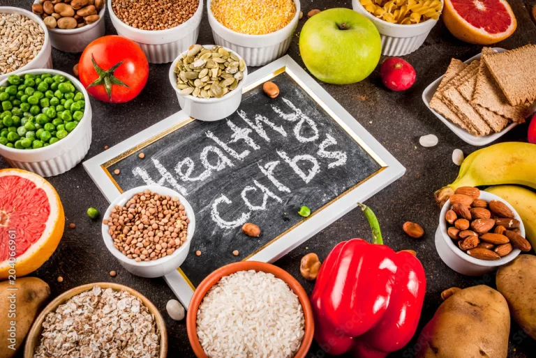 Diet food background concept, healthy carbohydrates (carbs) products - fruits, vegetables, cereals, nuts, beans, dark blue concrete background